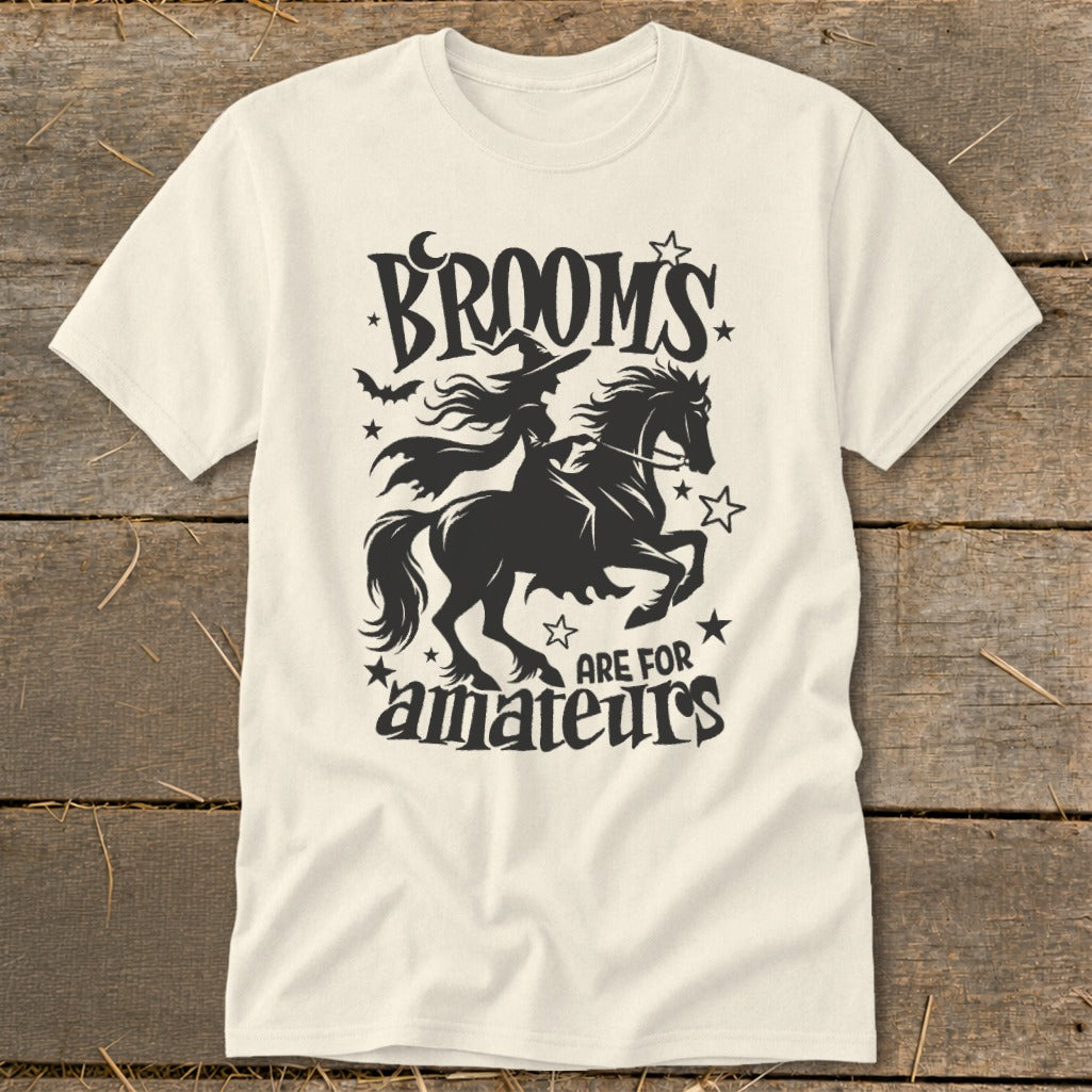 Cream t-shirt with black graphic of a witch riding a horse, saying "Brooms are for amateurs."