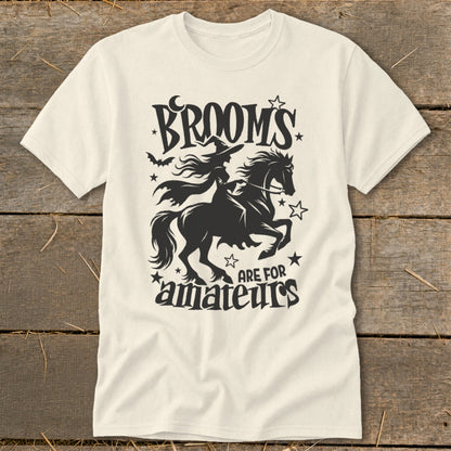 Cream t-shirt with black graphic of a witch riding a horse, saying "Brooms are for amateurs."