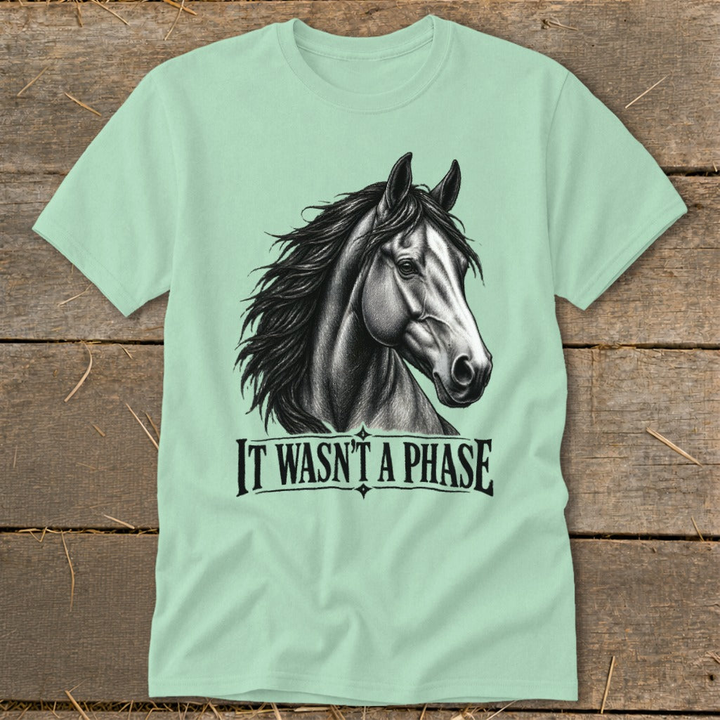 Light green t-shirt with a drawing of a horse head and the text "IT WASN'T A PHASE."