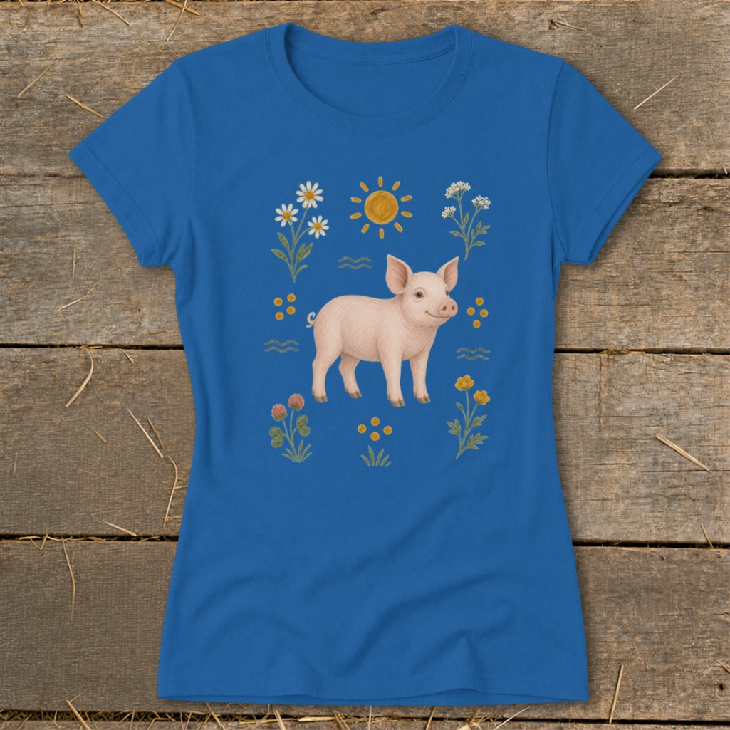 Blue t-shirt with a pink pig illustration surrounded by sun, flowers, and waves.