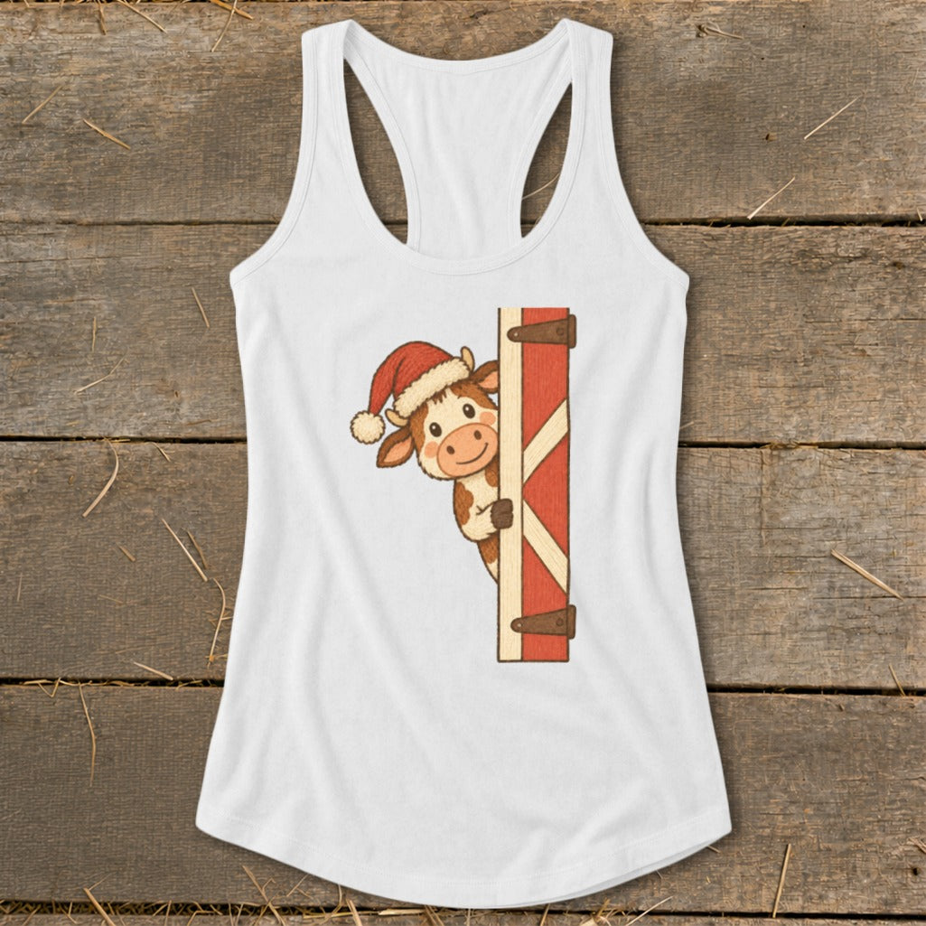 Cute cow wearing a Santa hat peeking from behind a red barn door.