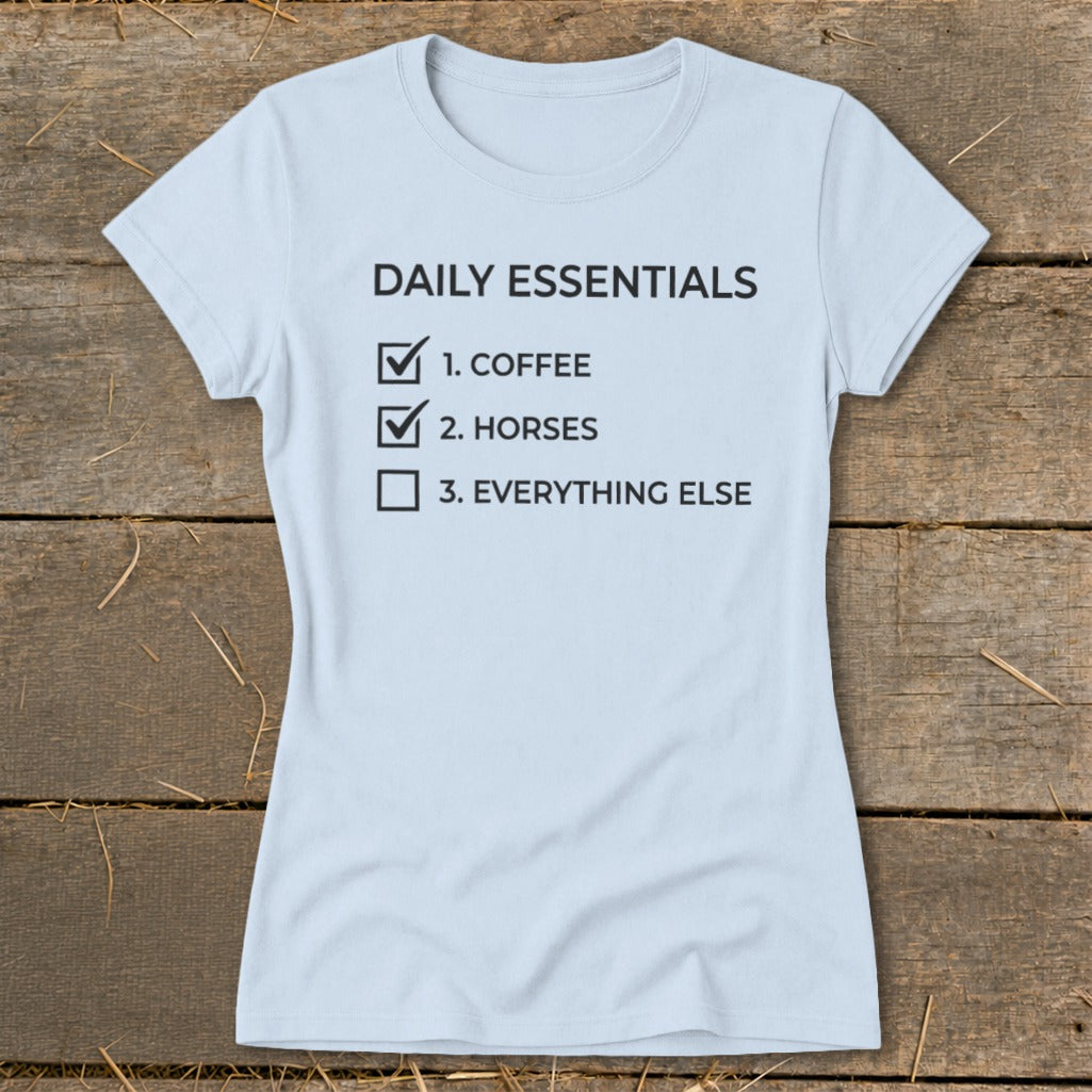 Light blue t-shirt with "Daily Essentials" and a checklist of coffee, horses, and everything else.