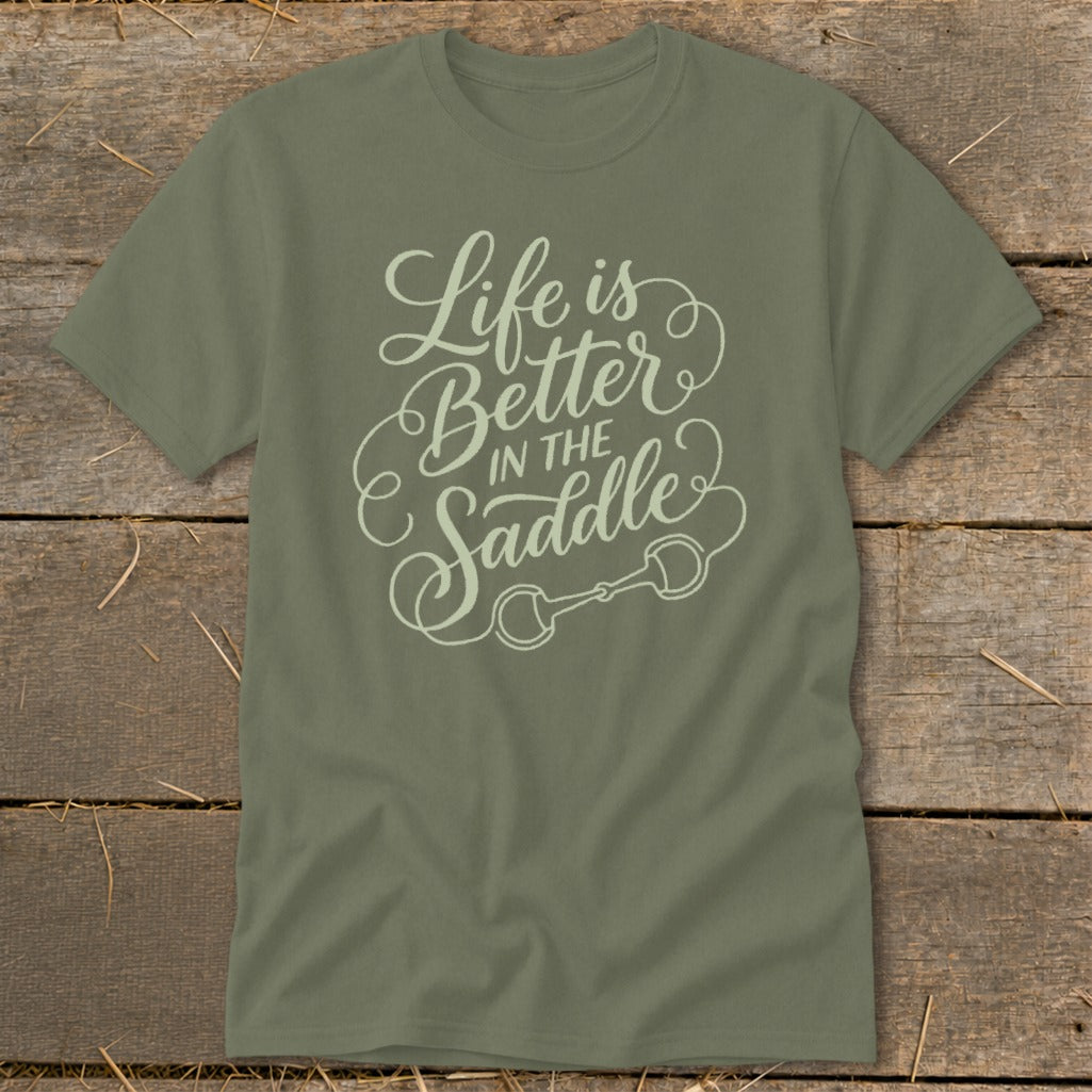 Olive green t-shirt with "Life is Better In The Saddle" text and horse bit graphic.