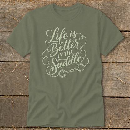 Olive green t-shirt with "Life is Better In The Saddle" text and horse bit graphic.