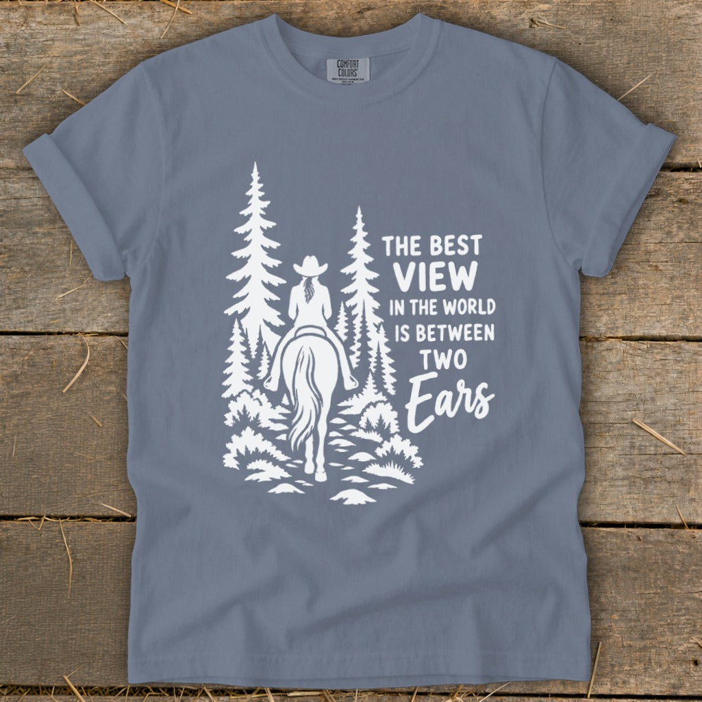 Blue t-shirt featuring a white graphic of a horseback rider and pine trees with text.