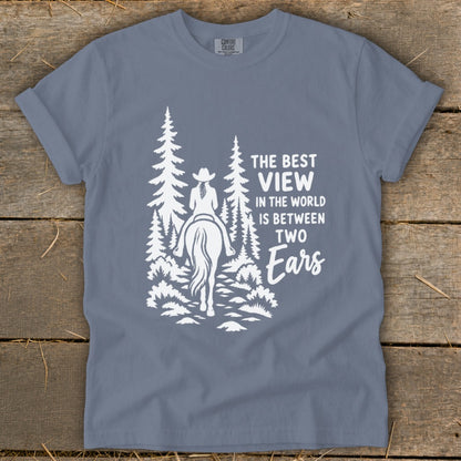 Blue t-shirt featuring a white graphic of a horseback rider and pine trees with text.