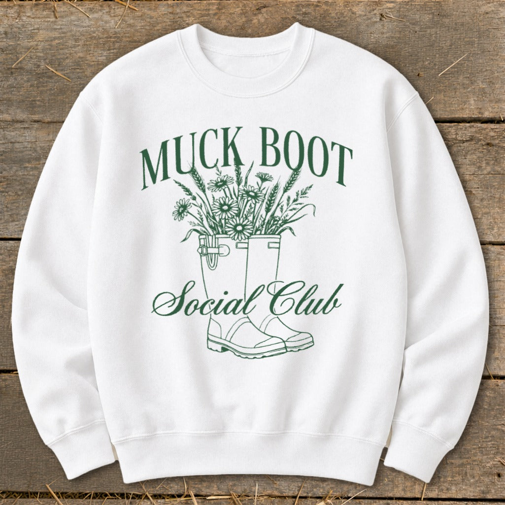 White sweatshirt with green "MUCK BOOT Social Club" text and flower graphic.