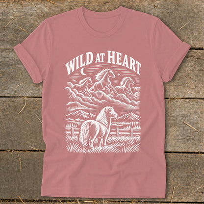 Pink t-shirt with white "Wild at Heart" text and horses in a mountainous landscape.