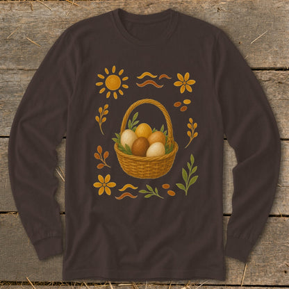 Long-sleeve brown shirt with Easter basket of eggs and floral, sun, and leaf motifs.