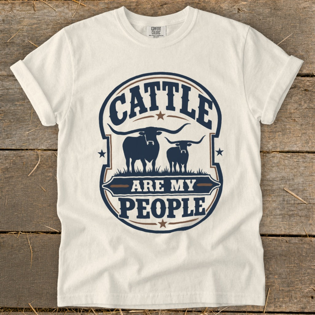 White t-shirt with blue graphic "Cattle Are My People" and two longhorn silhouettes.