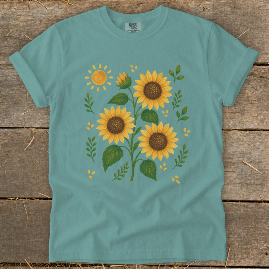 Teal t-shirt with a watercolor-style sunflower print and a bright sun.