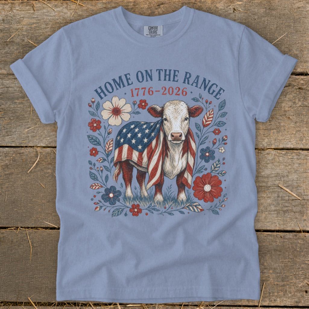 Cow wearing American flag, surrounded by flowers, with text "HOME ON THE RANGE 1776-2026".