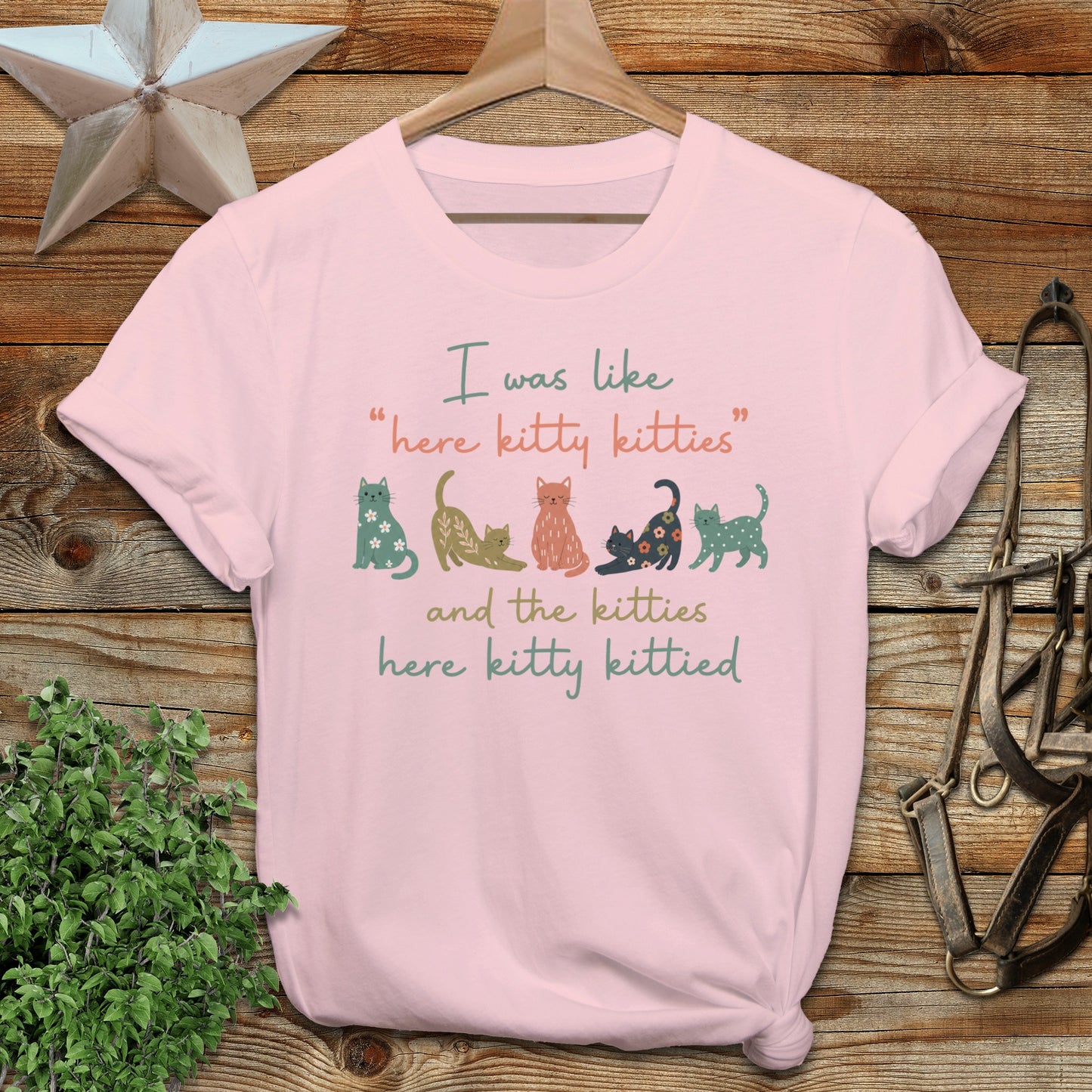 Pink t-shirt with "here kitty kitties" and cat illustrations.