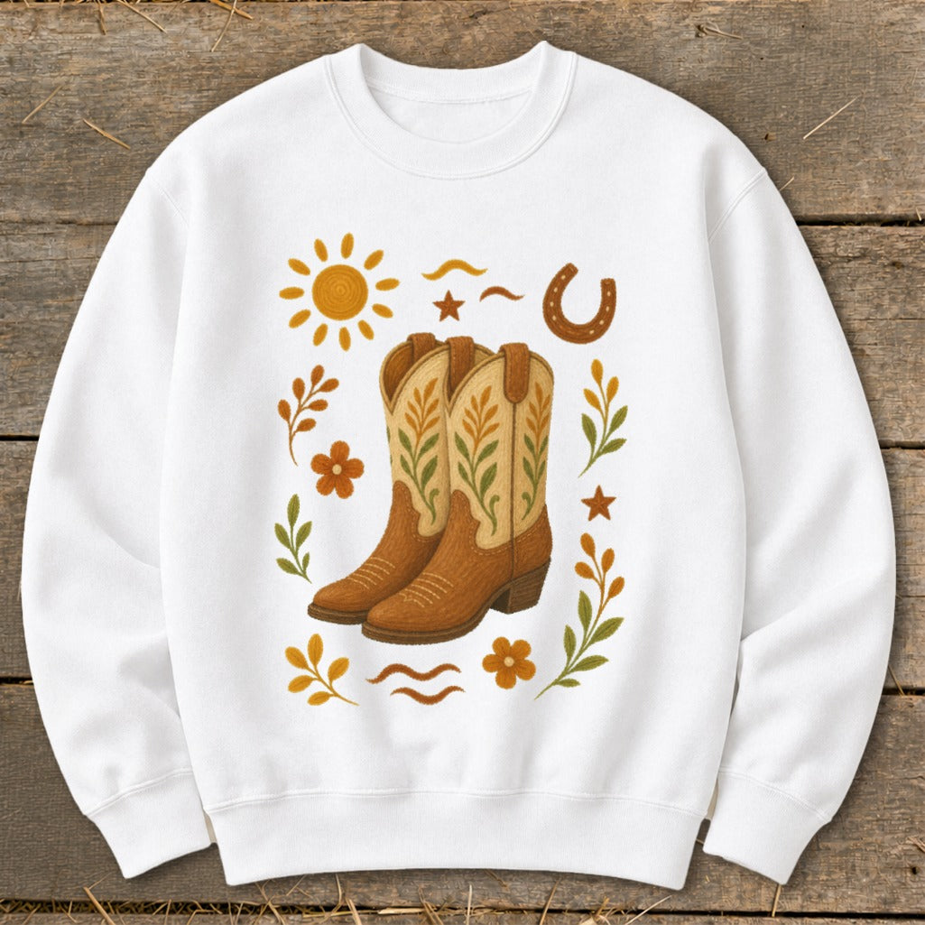 White sweatshirt with cowboy boots, sun, horseshoe, and floral accents.