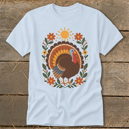 Light blue t-shirt with a cartoon turkey surrounded by flowers and a sun.