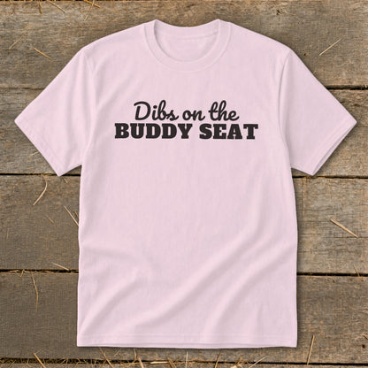 Pink t-shirt with "Dibs on the BUDDY SEAT" text in black.