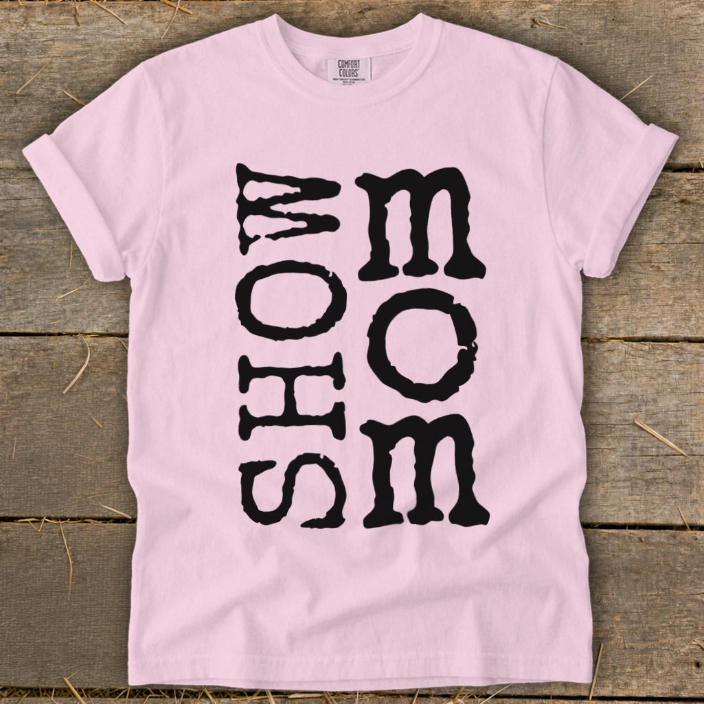 Pink t-shirt with vertical black text reading "MOM" and horizontal text "SHOW".