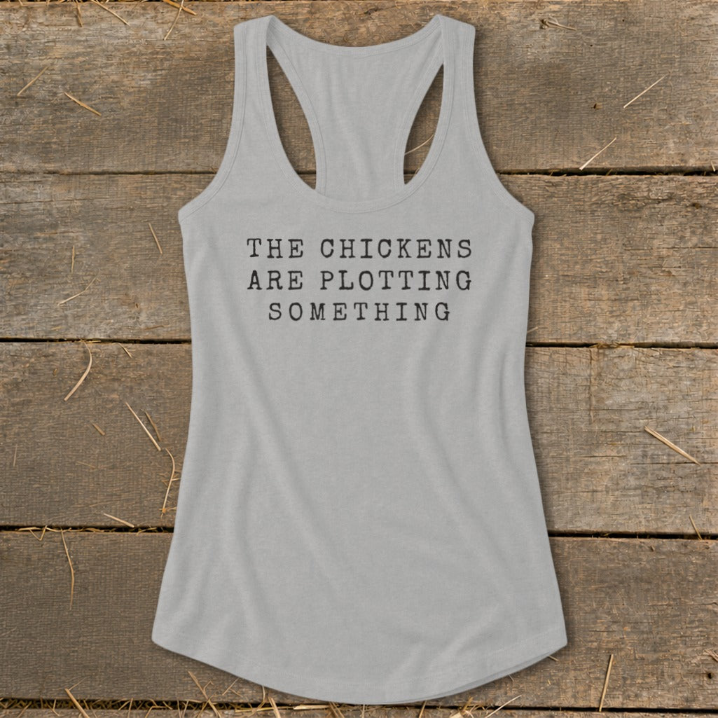 Grey racerback tank top with black text that reads "The chickens are plotting something".
