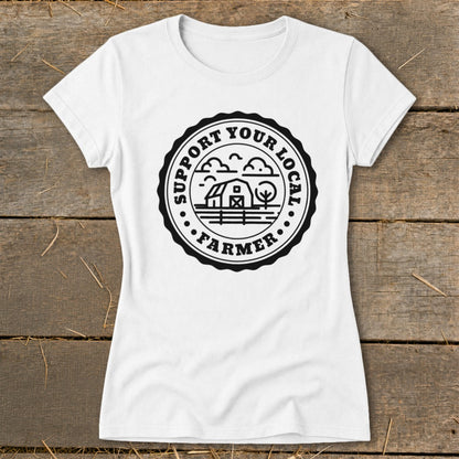 White t-shirt with black circular graphic reading "Support Your Local Farmer" and depicting a barn, trees, and clouds.