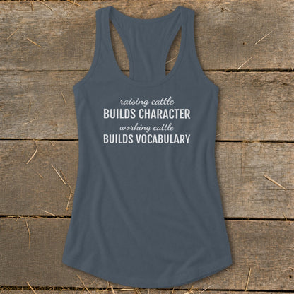 Gray racerback tank top with white text that reads "raising cattle BUILDS CHARACTER working cattle BUILDS VOCABULARY."