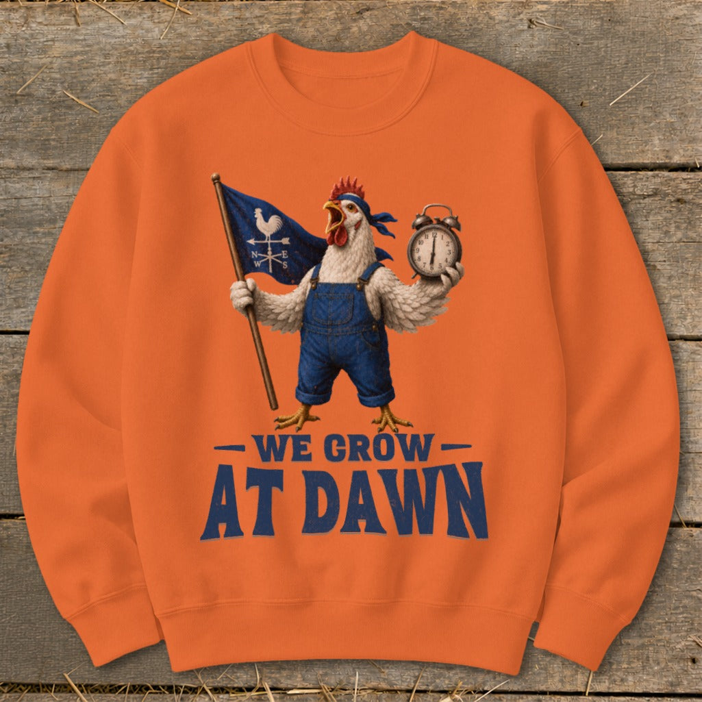Orange sweatshirt with a rooster holding a flag and alarm clock, text reads "We Grow At Dawn."