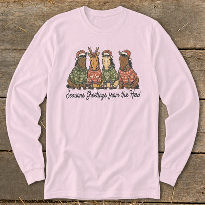 Four horses wear Santa hats and ugly Christmas sweaters. Text reads "Seasons Greetings from the Herd".