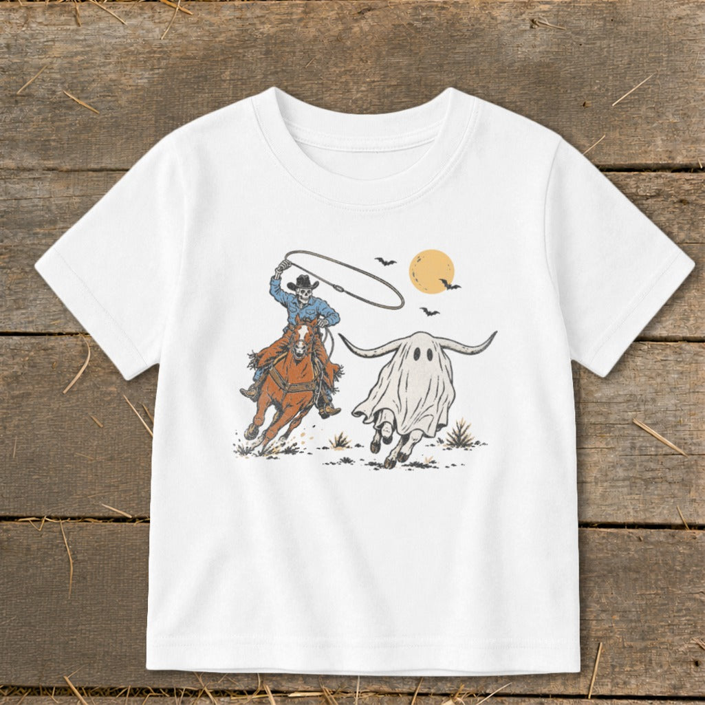 Skeleton cowboy on horseback lassoing a ghost longhorn with bats and moon.
