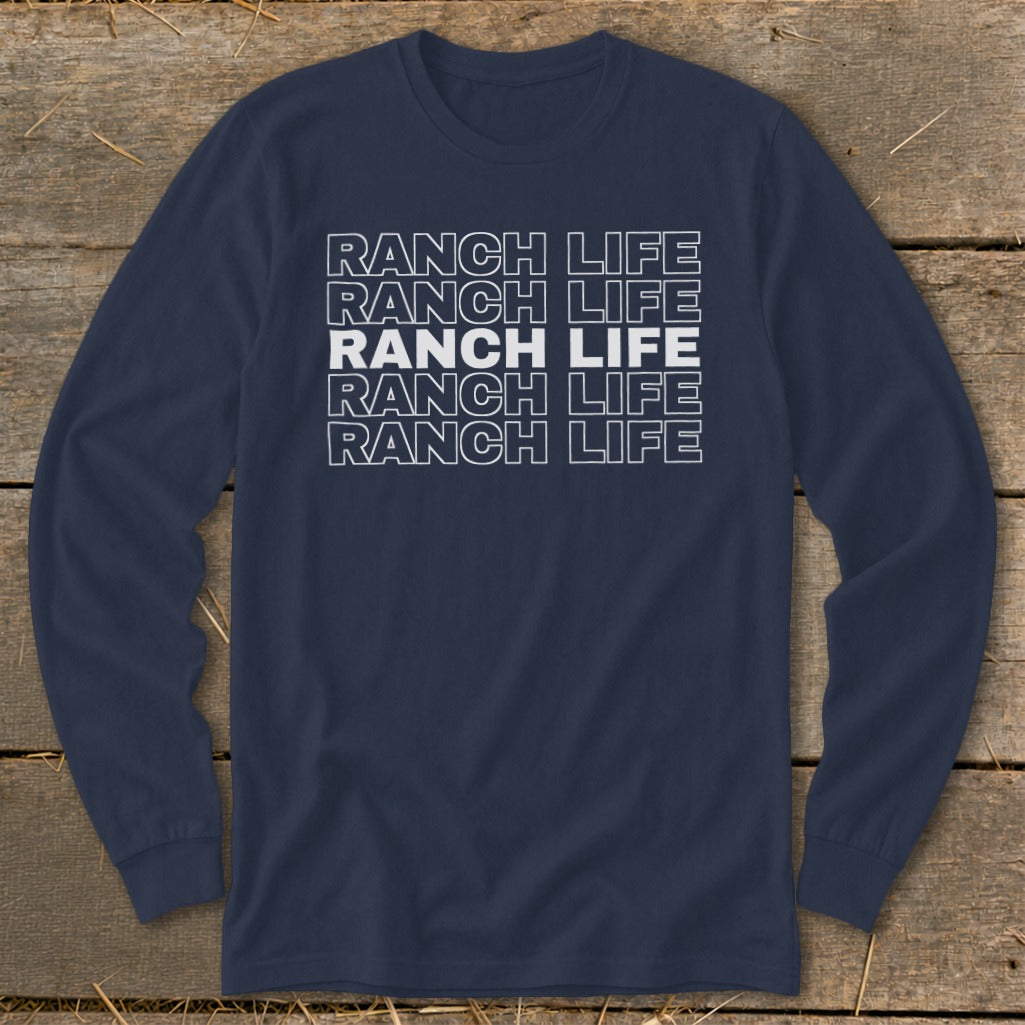Navy blue long-sleeved t-shirt with white block text reading Ranch Life repeated five times against a wooden background.