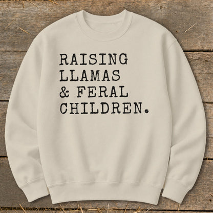 Cream sweatshirt with black text reading "RAISING LLAMAS & FERAL CHILDREN."
