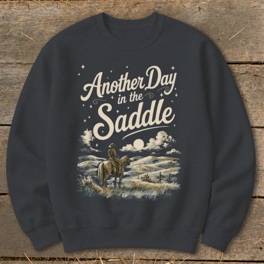 Dark grey sweatshirt with "Another Day in the Saddle" text and cowboy on horseback scene.
