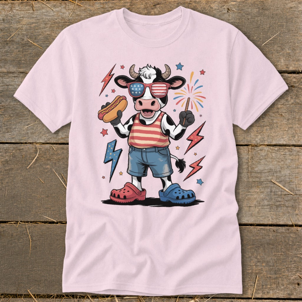 Cartoon cow in patriotic outfit holding hot dog and sparkler with fireworks.
