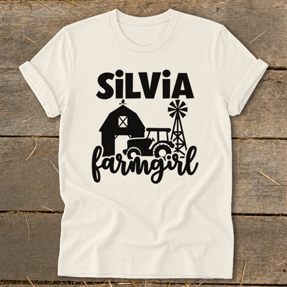 Cream t-shirt with "Silvia" and "farmgirl" text with barn, tractor, and windmill graphics.