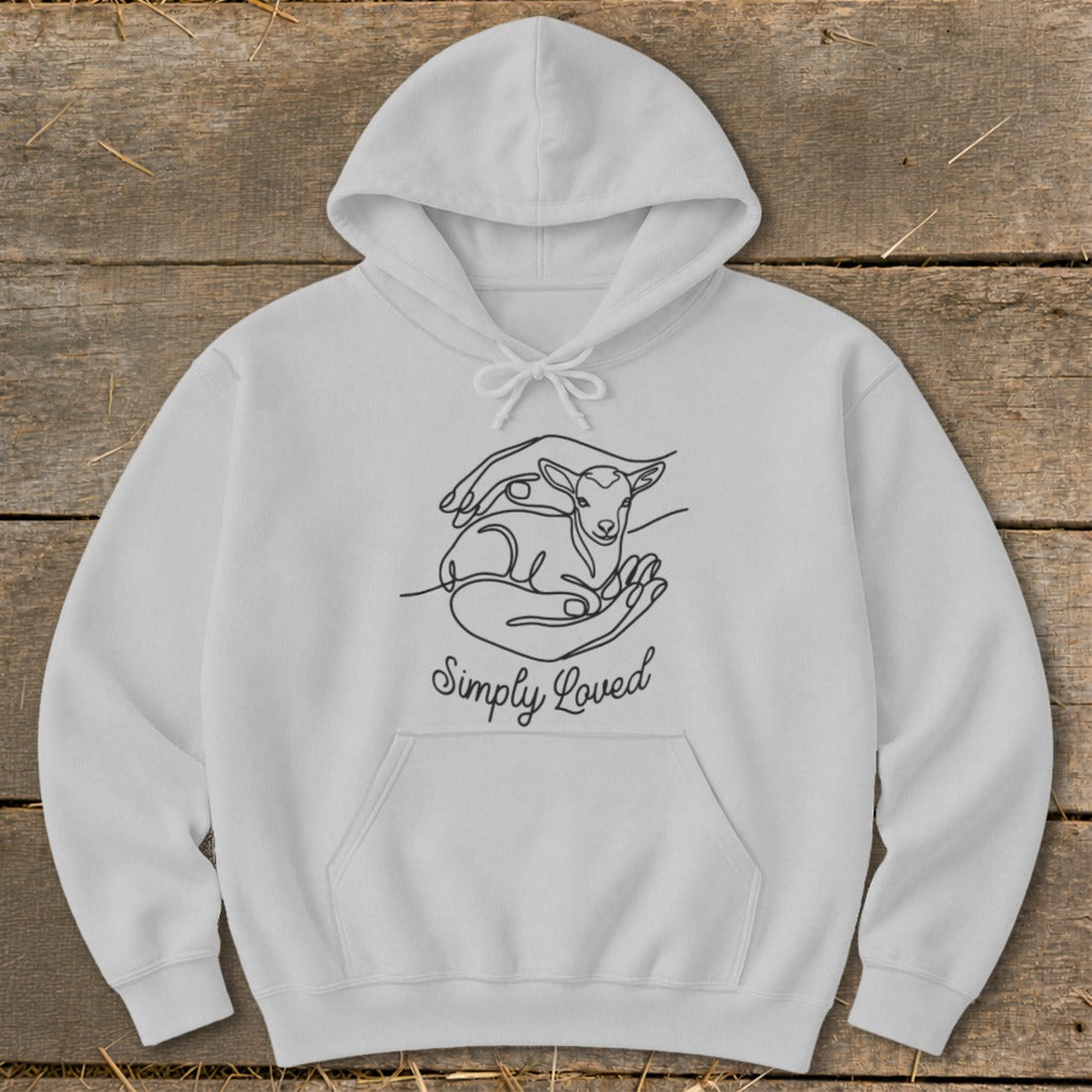 White hoodie with a black line drawing of hands holding a lamb and text "Simply Loved."