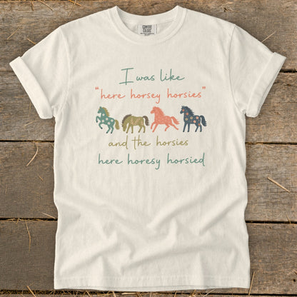 Cream t-shirt with text and four colorful horse illustrations.