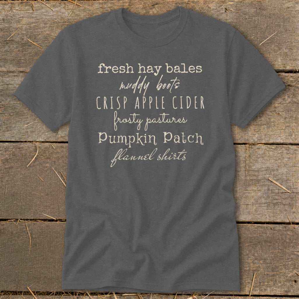 Gray t-shirt with text listing fall themes: "fresh hay bales, muddy boots, crisp apple cider, frosty pastures, pumpkin patch, flannel shirts."