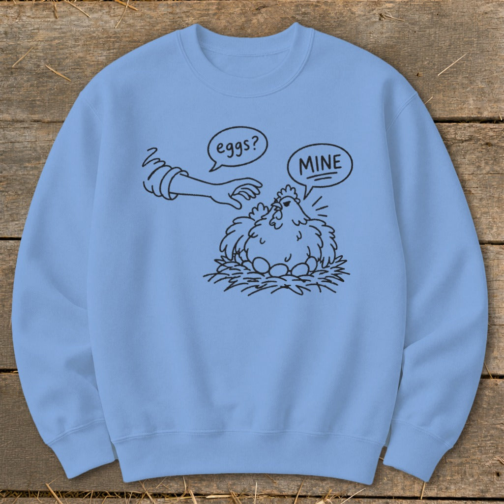 Light blue sweatshirt with a drawing of a chicken protecting its eggs from a hand.