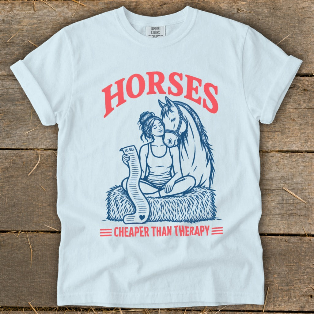White t-shirt with "HORSES CHEAPER THAN THERAPY" and illustration of woman with horse and vet bill.