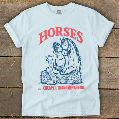 White t-shirt with "HORSES CHEAPER THAN THERAPY" and illustration of woman with horse and vet bill.