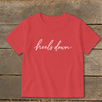 Red t-shirt with "heels down" in white cursive text.