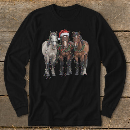 Three horses adorned with Christmas lights and garland, one wearing a Santa hat.