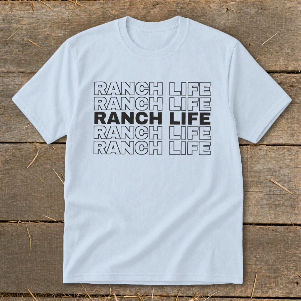 Light blue t-shirt featuring repeated black text reading RANCH LIFE on a wooden surface.