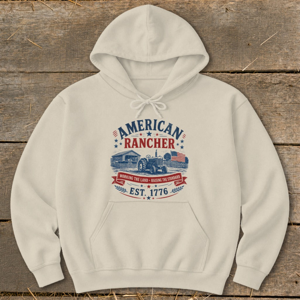 Cream hoodie with "American Rancher Est. 1776" graphic featuring a barn and tractor.