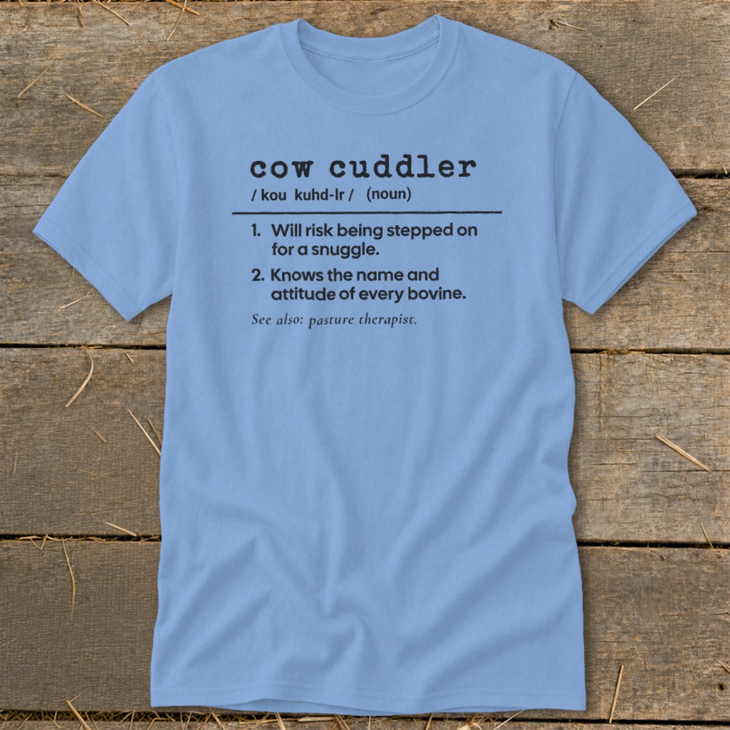 Light blue t-shirt with black text defining "cow cuddler."