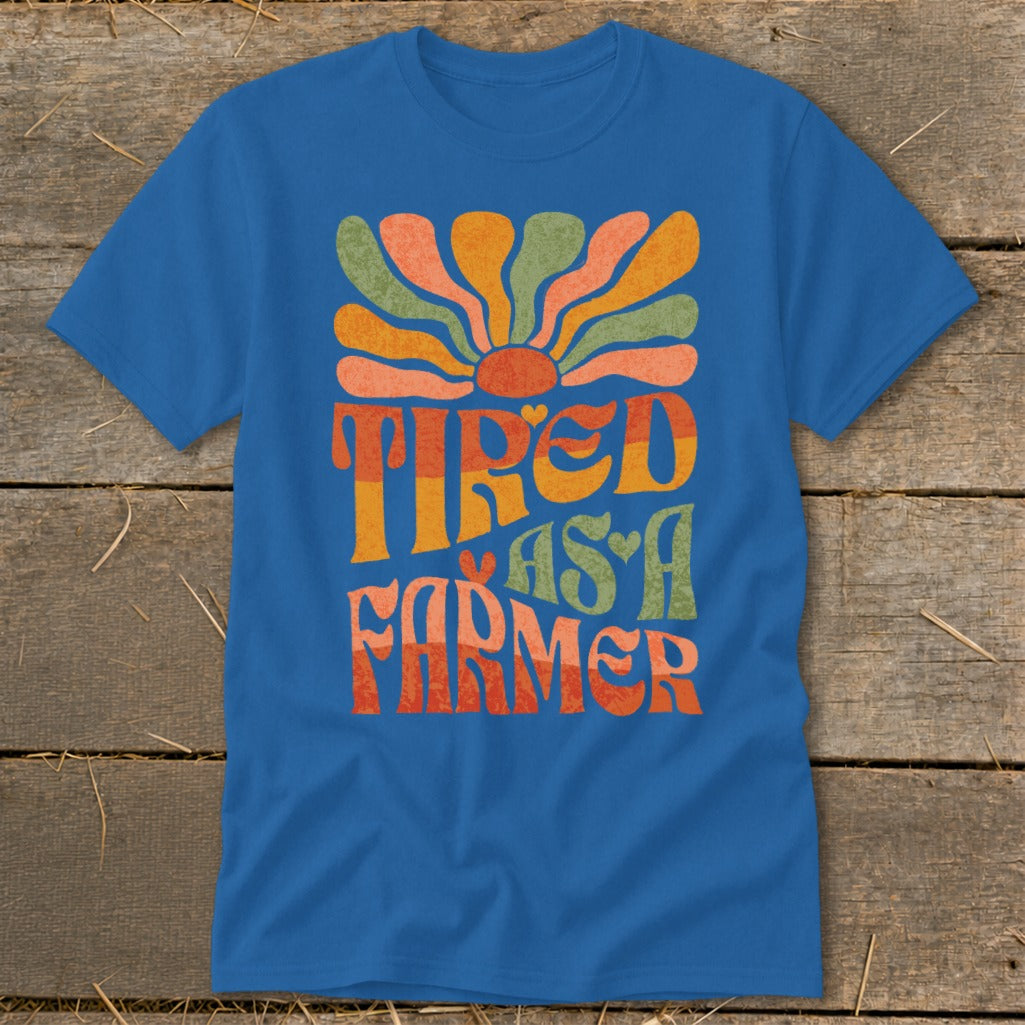 Blue t-shirt with "Tired As A Farmer" text and a retro sun graphic.