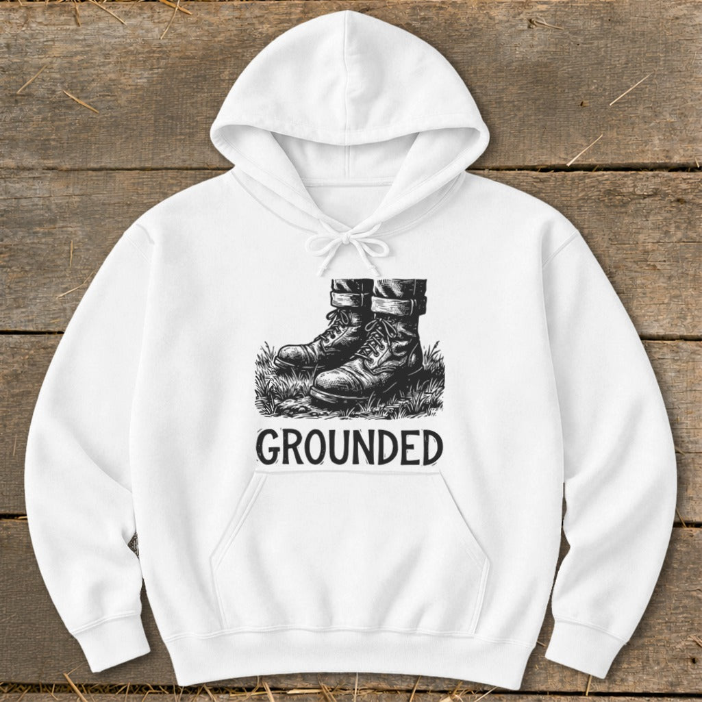 White hoodie with graphic of boots on grass and text "GROUNDED".