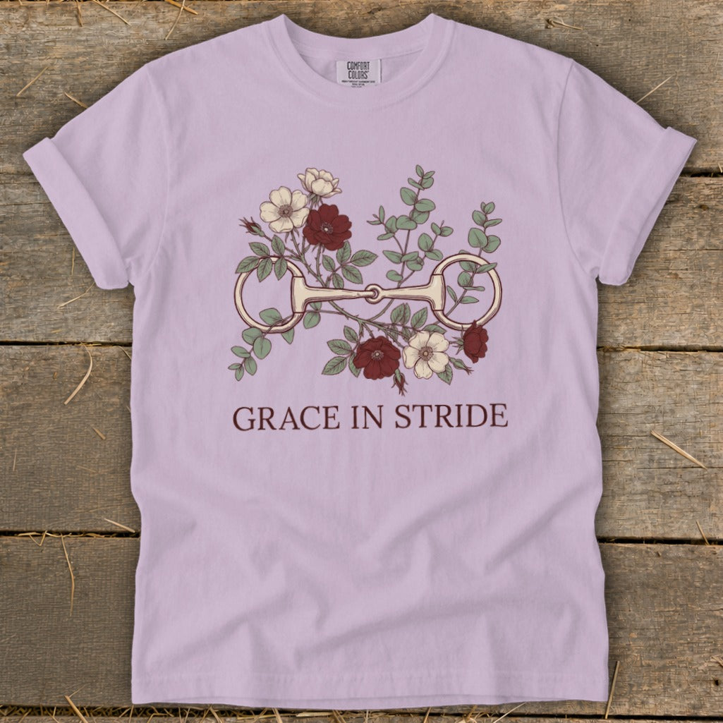 Light purple t-shirt with a horse bit and floral design, text "GRACE IN STRIDE".
