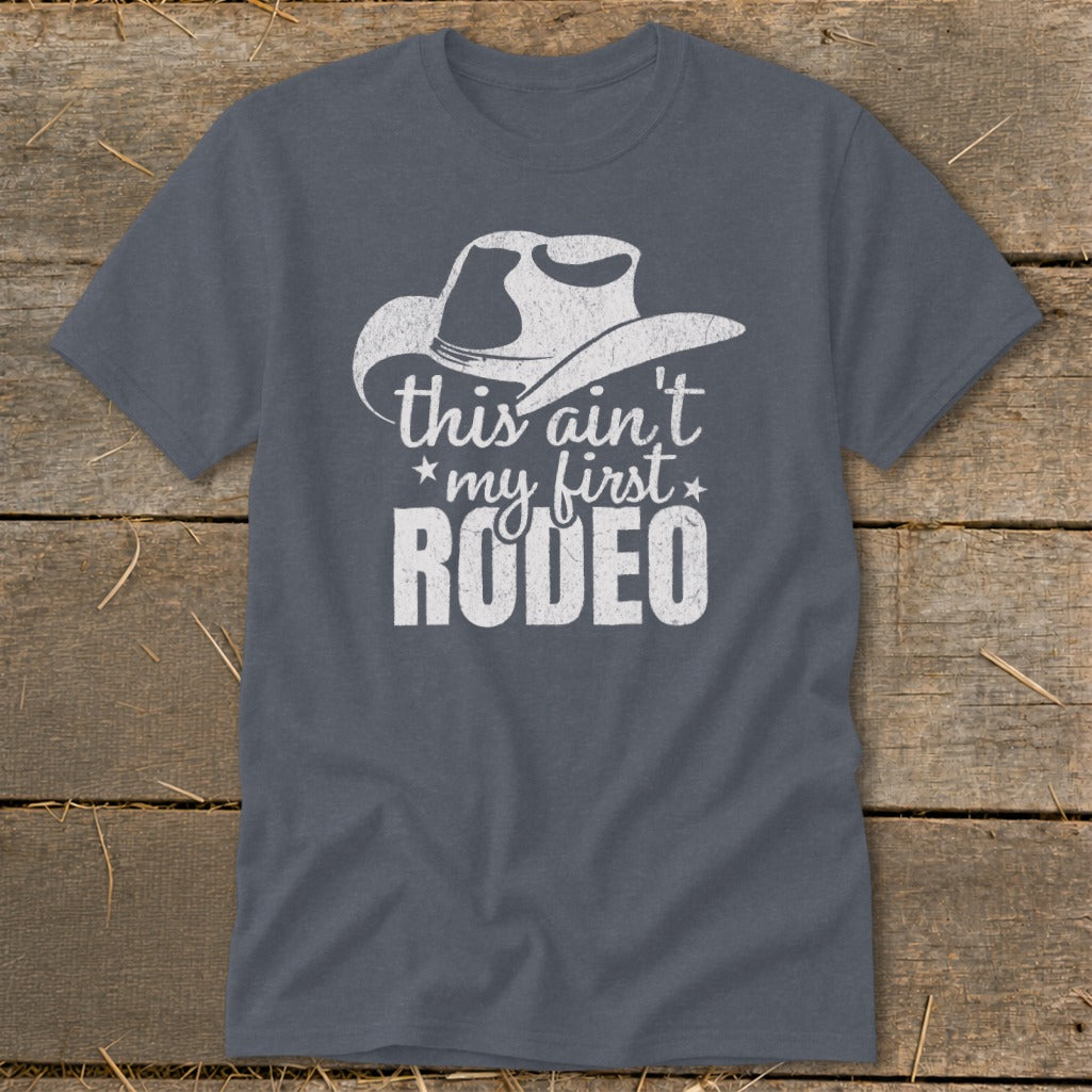 Gray t-shirt with white cowboy hat graphic and "this ain't my first RODEO" text.