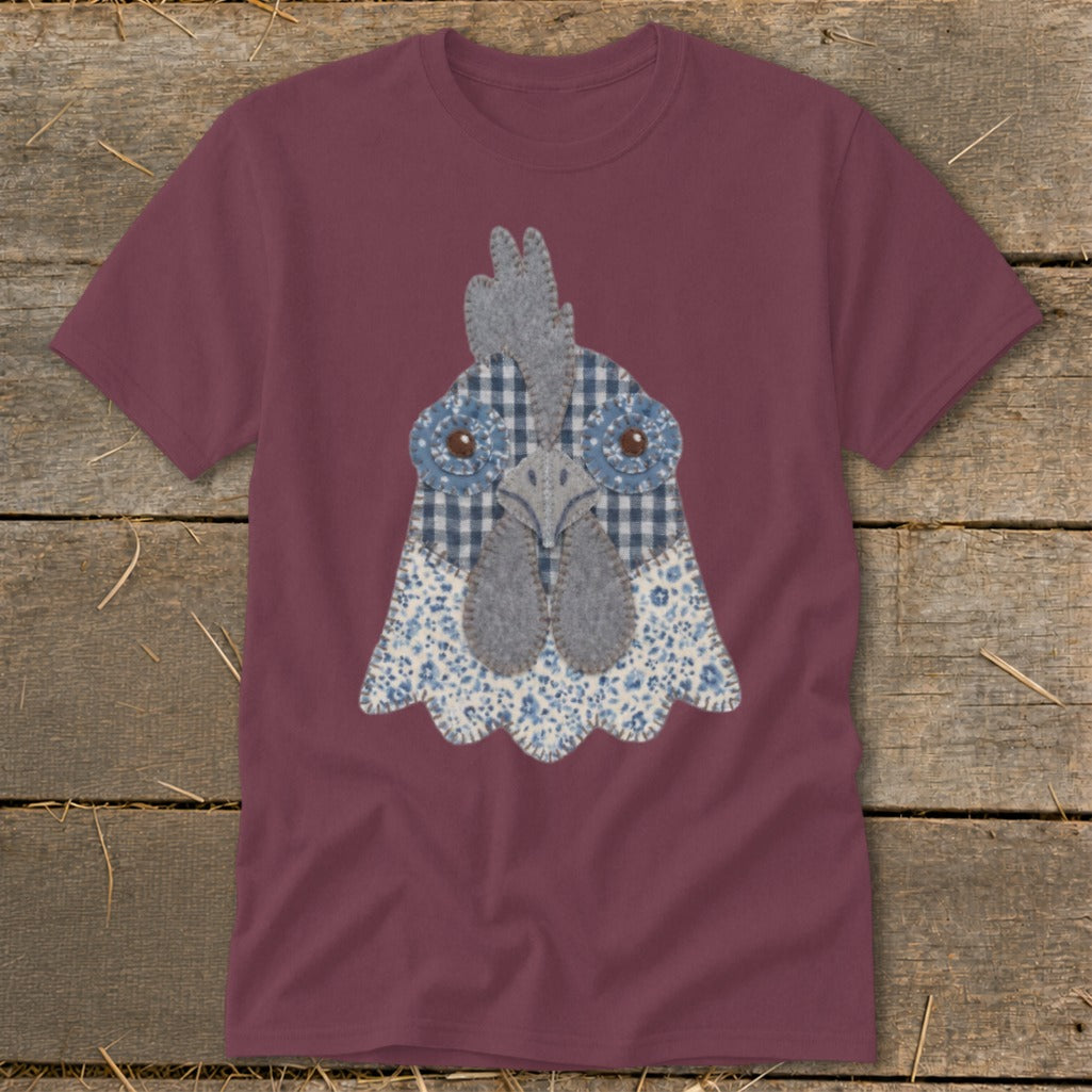 Maroon t-shirt with a decorative appliquéd chicken head design.