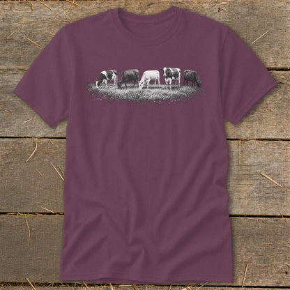 T-shirt with a print of five cows grazing in a field of wildflowers.