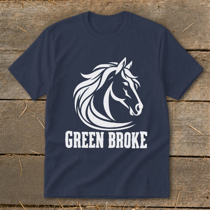 Navy blue t-shirt featuring a white horse head logo and the text Green Broke laid flat on a wooden surface.